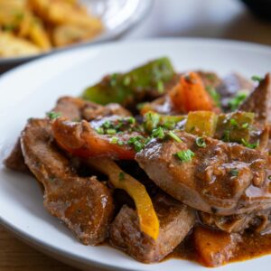 A mouthwatering plate of beef stir fry garnished with vibrant vegetables, perfect for a tasty dinner.